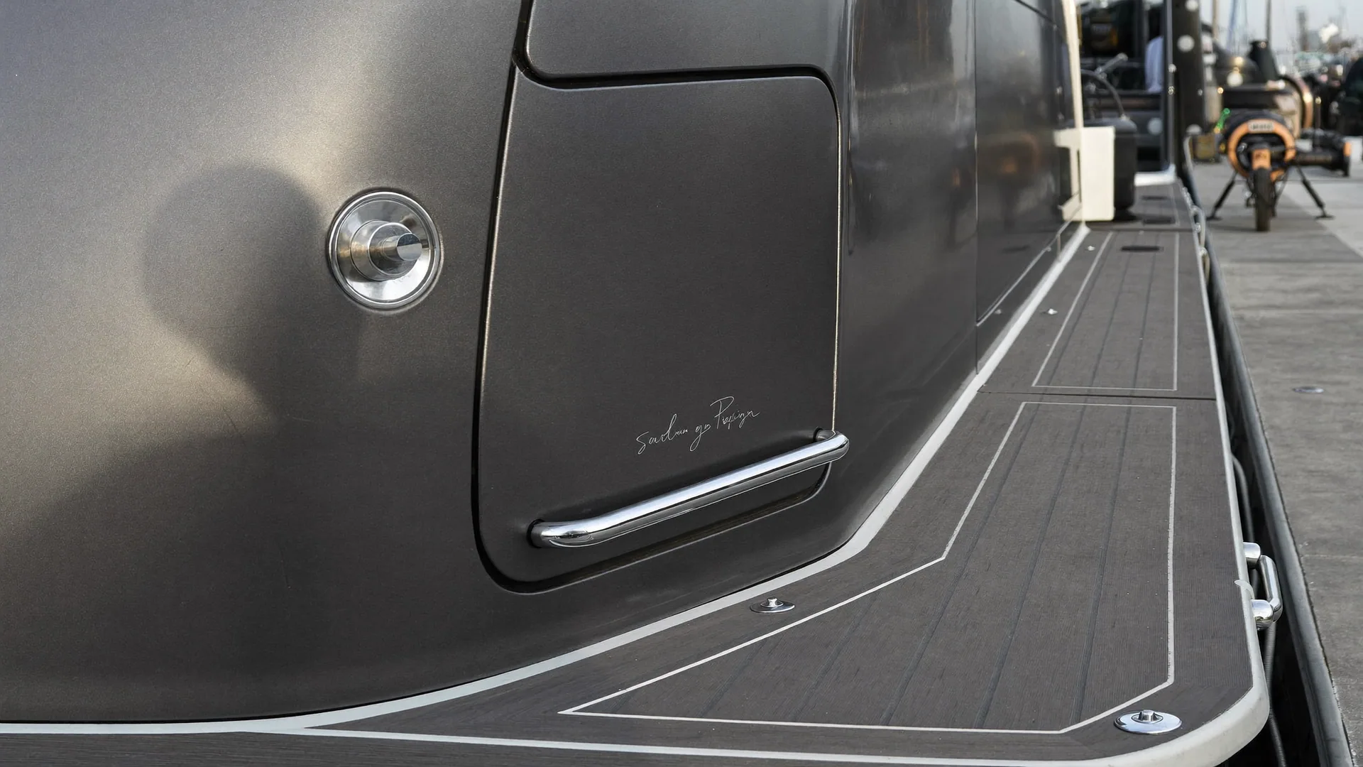 Wide service view of a graphite grey cabin cruiser at a marina berth with a moulded non-sk during boat detailing